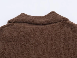 Macro detail of the dark brown boucle fleece fabric and collar seam on this bomber jacket