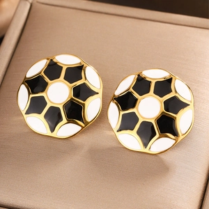 Macro shot of 18K gold plated football earrings with black and white enamel detail