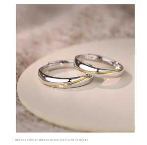 Macro shot of mirror-polished silver rings with golden spiral wire detail and matte finish