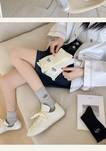 Detail of knit cotton socks featuring a delicate logo embroidery on the ribbed cuff