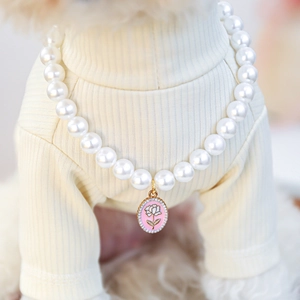 Detailed macro view of pet pearl necklace featuring pink floral pendant and crystal borders