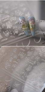 Detail von 5D-Relief-Nagelaufklebern mit weißen Blumen, Schmetterlingen und LOVE-Schrift
