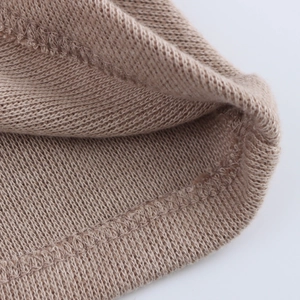 Detailed macro view of light brown knit fabric texture and high-quality stitching detail