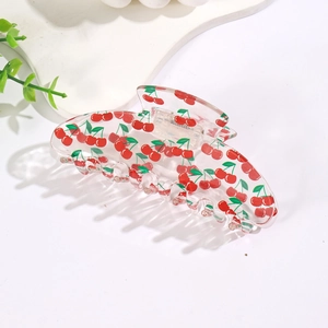 Transparent acrylic hair claw clip with cherry print design on a minimalist white setting