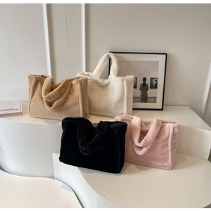 Sacs cabas en peluche en kaki, blanc, noir et rose sur un support d'exposition épuré