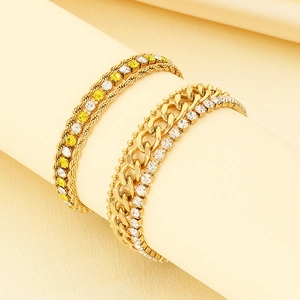 Close-up of gold twist and curb chains with yellow and white zircon inlays on a display