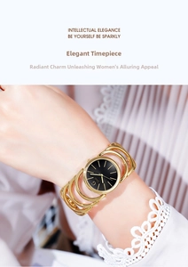 Close-up of Gedi gold bracelet watch with black dial worn over elegant white lace