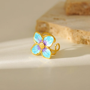 Macro shot of gold-plated stainless steel ring with blue and purple enamel flower petals