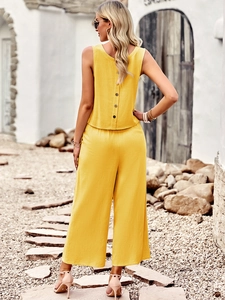 Detail view of yellow linen-style two-piece set featuring back button accents on top