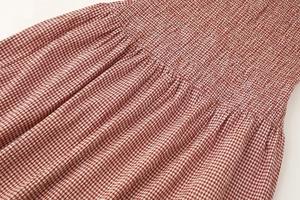 Gros plan détaillé du tissu vichy rouge et blanc avec des détails de smocks élastiques