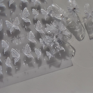Detail of 3D jelly texture nail stickers featuring white butterfly and star patterns