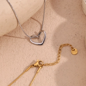 Detail of stainless steel heart necklace with lobster clasp, extender chain and logo tag