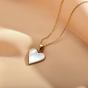 Detail of a heart-shaped necklace with white mother of pearl inlay on champagne silk