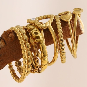 Nahaufnahme eines 18K vergoldeten Edelstahl-Ring-Sets an einem Zweig aus Holz