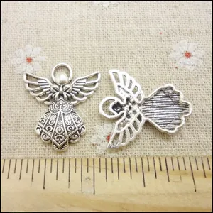 Detailed view of vintage silver angel charm showing hollow carving and bow design on scale