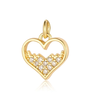 Macro shot of a golden heart pendant with shimmering zircon pavé stones on a white background