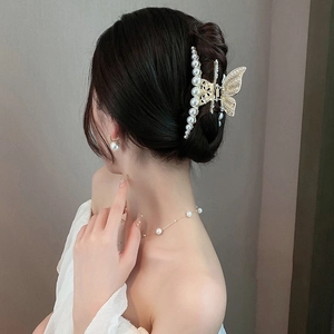 Elegant gold butterfly hair claw clip with diamonds and pearls shown on model's hair