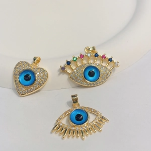Gold evil eye heart and eye pendants with colorful zircon inlays on white background