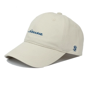 Détail de la casquette crème avec broderie sienne bleue et visière incurvée élégante