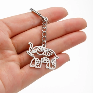 Polished stainless steel elephant keychain with bohemian cutout patterns on white background