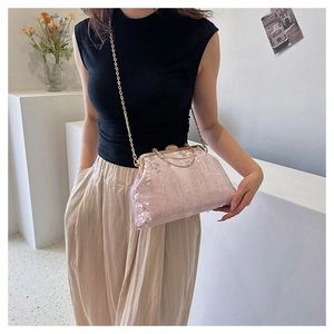 Pink sequin evening bag shown on model with gold chain strap and metal handle