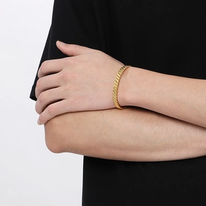Men's golden C-shaped textured bangle with intricate diagonal weave pattern worn by model