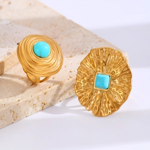 Detailed shot of vintage gold rings with green turquoise and textured metal patterns