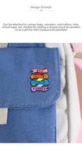 Detail of colorful enamel ribbon brooch with motivational text on blue canvas bag