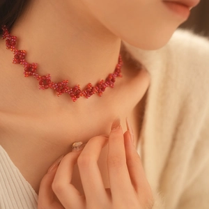 Close-up of red beaded floral choker necklace showing detailed weaving on the neck