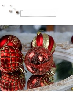 Detail of red and gold Christmas ornaments with glitter patterns on vintage mirror tray