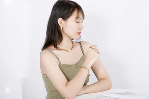 Golden Cuban chain jewelry set with square pendant worn by a model on white background