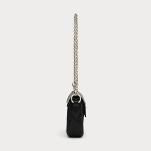 Profil latéral du sac bandoulière en cuir noir avec chaîne argentée et œillets en métal
