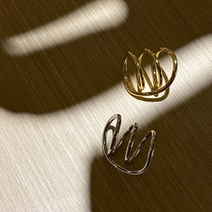 Minimalist gold and silver layered ear cuffs set displayed on a rustic wooden surface