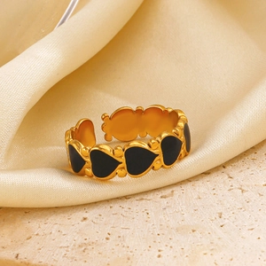 Vintage golden adjustable open ring with black enamel hearts on a silk background