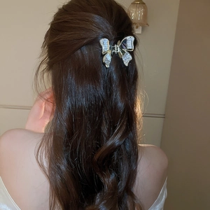 Dettaglio della pinza per capelli a farfalla in zircone con ali di madreperla lucenti