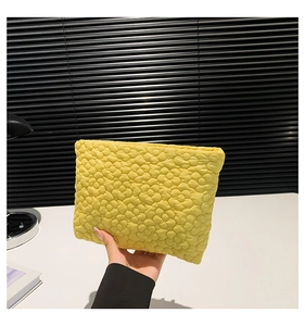 Detailed close-up of a bright yellow quilted bag featuring textured 3D floral patterns