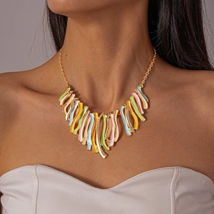 Macro detail of multicolored enamel wave tassels on a minimalist golden chain necklace