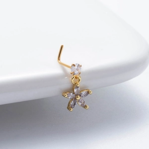Makroaufnahme von L-förmigem Gold-Nasenstecker mit funkelndem Zirkon-Blumenanhänger