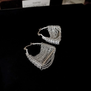 Detail of silver tassel earrings with sparkling cubic zirconia and tiered metal chains