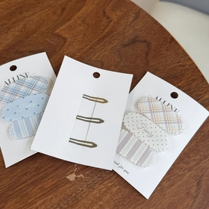 Close-up of sweet patterned BB hair clips showing heart, plaid, and stripe designs