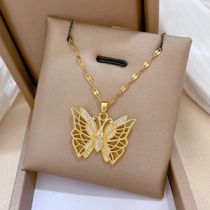 Exquisite gold-plated hollow butterfly necklace with micro-pave crystals on a beige display