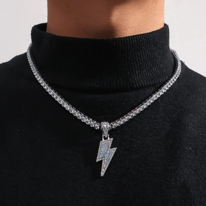 Close-up of hip-hop silver lightning pendant with blue and white zircons on a tennis chain