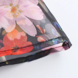 Floral organza sundress fabric detail with vibrant flower patterns and stitching