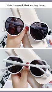 Detailed view of white hexagonal sunglasses with grey lenses and stylish geometric frame