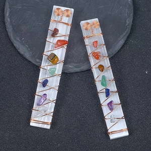 Dettaglio di bastoncini di selenite avvolti in filo di rame con pietre chakra