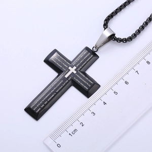 Detailed view of black stainless steel cross pendant showing 5.5cm height on scale
