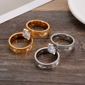 Detail of gold and silver plated titanium steel rings with hollow patterns and round zircons