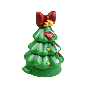 Detail of wind-up green Christmas tree toy with red bow, gold bell and heart patterns