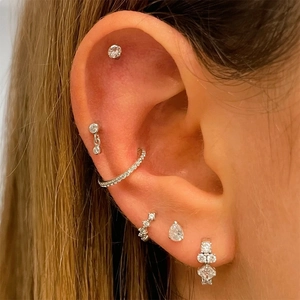 Macro shot of silver S925 earrings set with sparkling cubic zirconia on a model ear