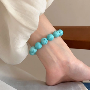 Close-up of minimalist faux turquoise beaded anklet on ankle with smooth sky blue finish